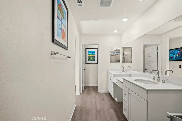 a spacious bathroom with a double vanity sink a mirror and a shower