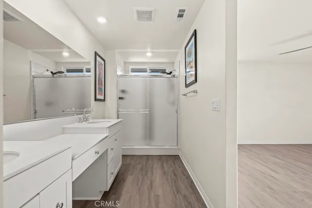 a bathroom with a double vanity sink a mirror and a shower