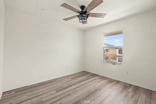 an empty room with a window and a fan