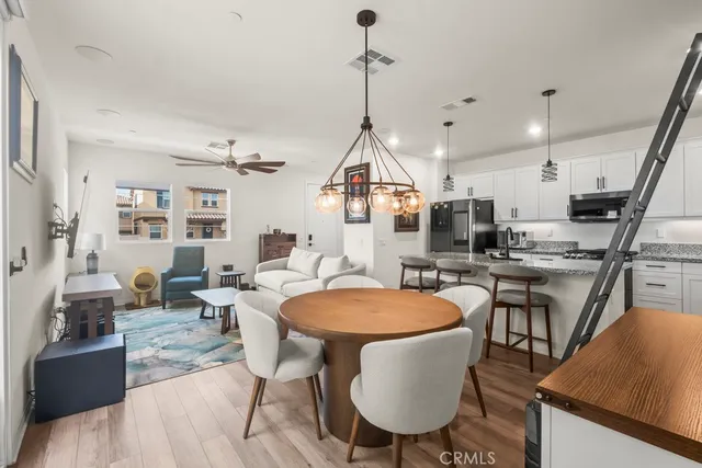 a dining room with stainless steel appliances kitchen island granite countertop a table chairs and a kitchen view