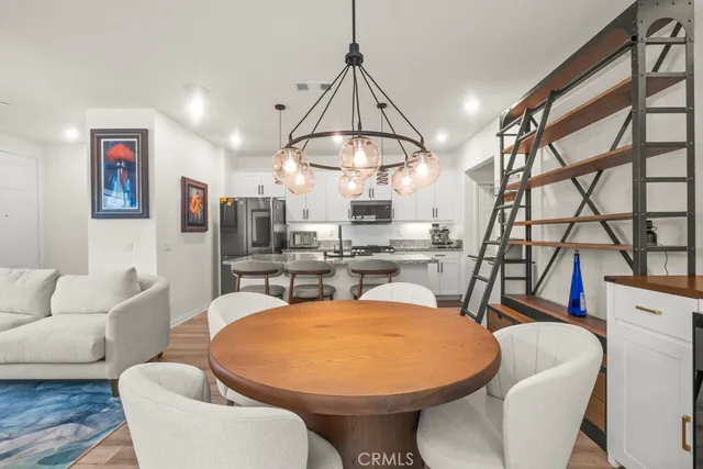 a view of a dining room with furniture a chandelier and wooden floor