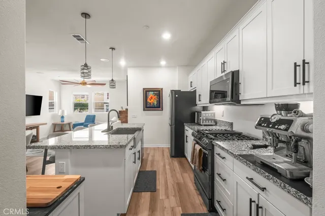 a kitchen with kitchen island stainless steel appliances a sink stove and refrigerator