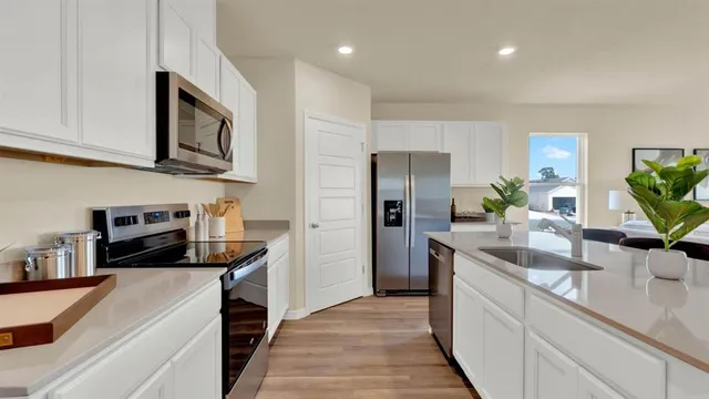a kitchen with stainless steel appliances granite countertop a sink a stove and a refrigerator