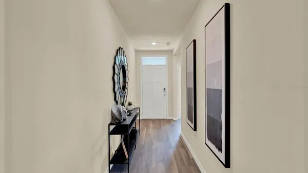 a view of a hallway with wooden floor and stairs