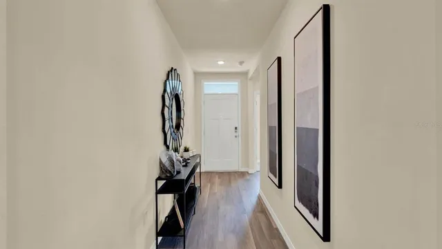 a view of a hallway with wooden floor and stairs