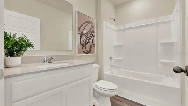 a bathroom with a granite countertop sink a toilet and shower