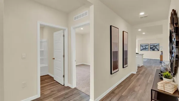 a view of a hallway with wooden floor and entryway