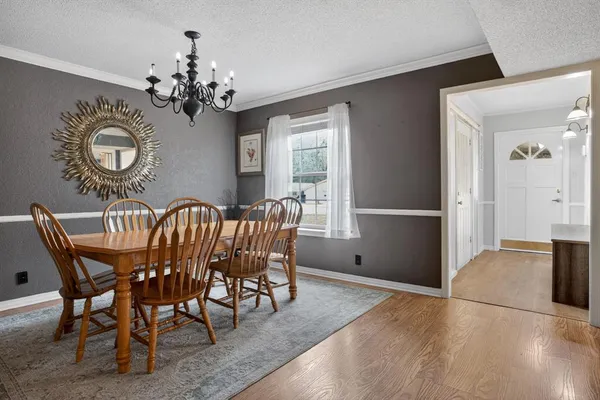 a view of a dining room with furniture a chandelier and wooden floor