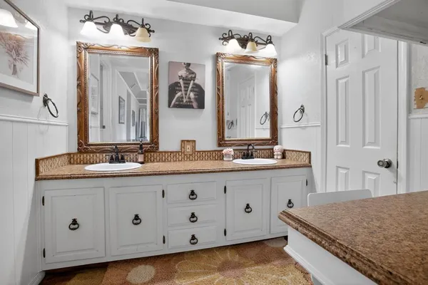a bathroom with a granite countertop double vanity sink and mirror