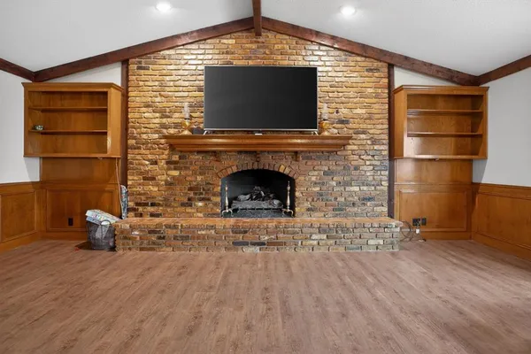 a living room with furniture wooden floor and a fireplace