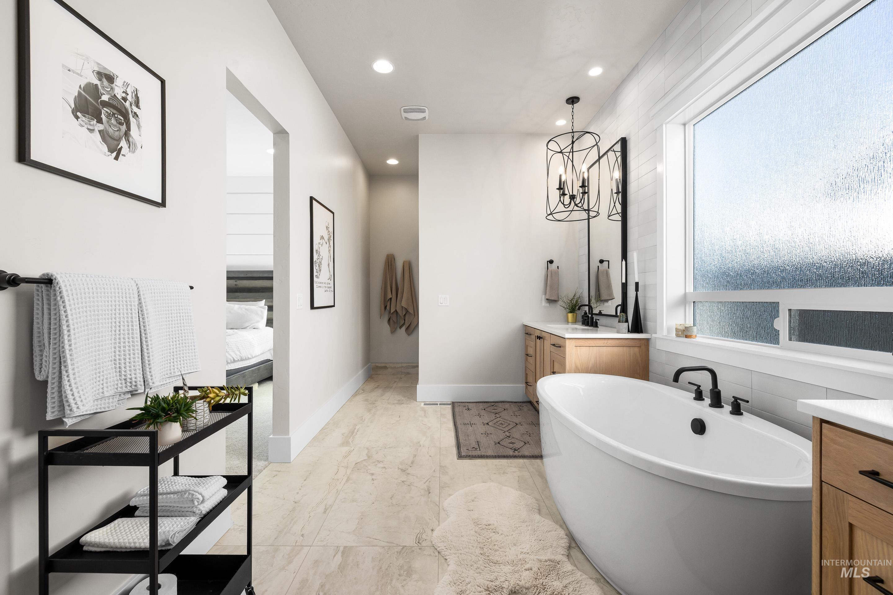 4217 North Bryant Way Meridian, ID 83646 - Photo 24 of 46 Ensuite bathroom featuring vanity, a freestanding bath, recessed lighting, and a chandelier