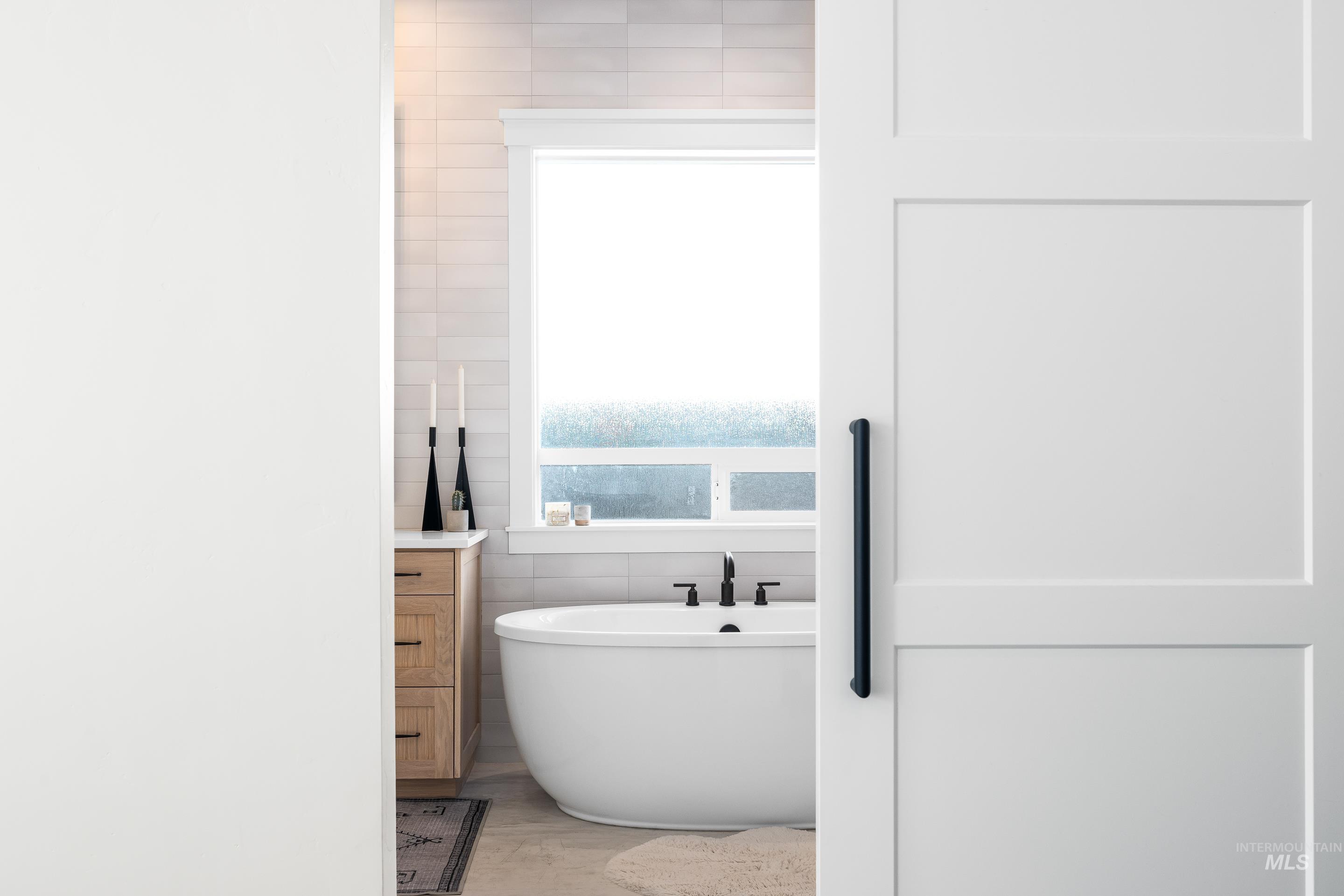 4217 North Bryant Way Meridian, ID 83646 - Photo 25 of 46 Full bathroom with a soaking tub, tile walls, and light wood-style floors