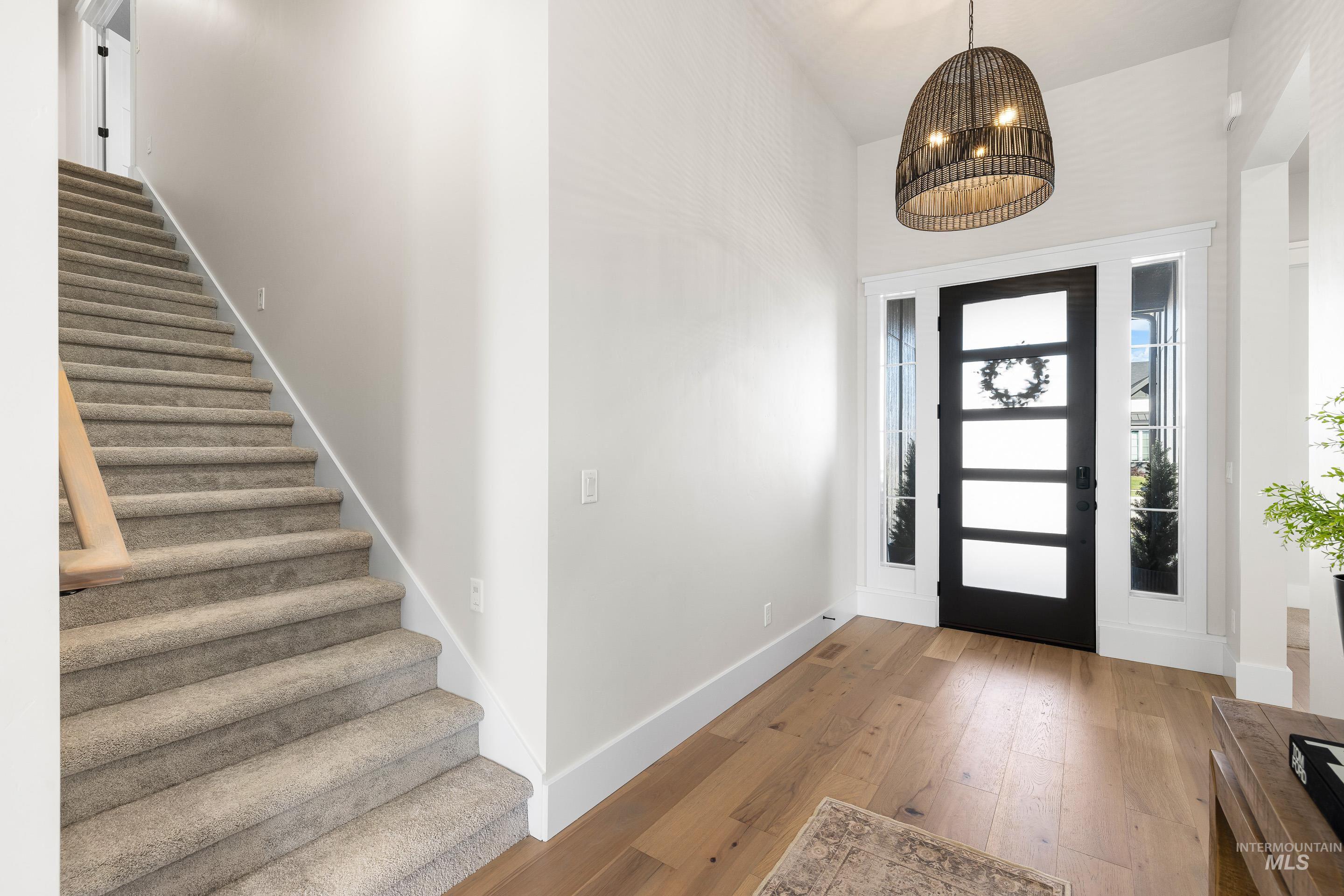 4217 North Bryant Way Meridian, ID 83646 - Photo 5 of 46 Foyer featuring hardwood / wood-style floors, stairway, and a chandelier