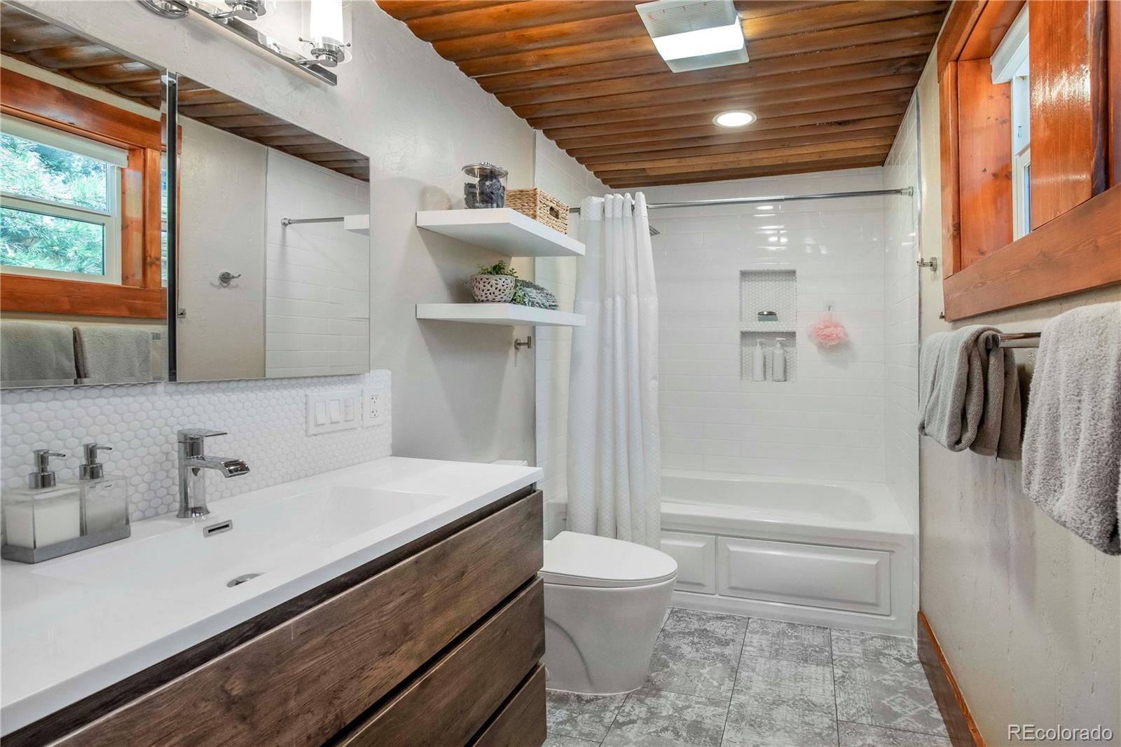 4805 Blue Spruce Road Evergreen, CO 80439 - Photo 17 of 43 a bathroom with a sink a toilet and shower