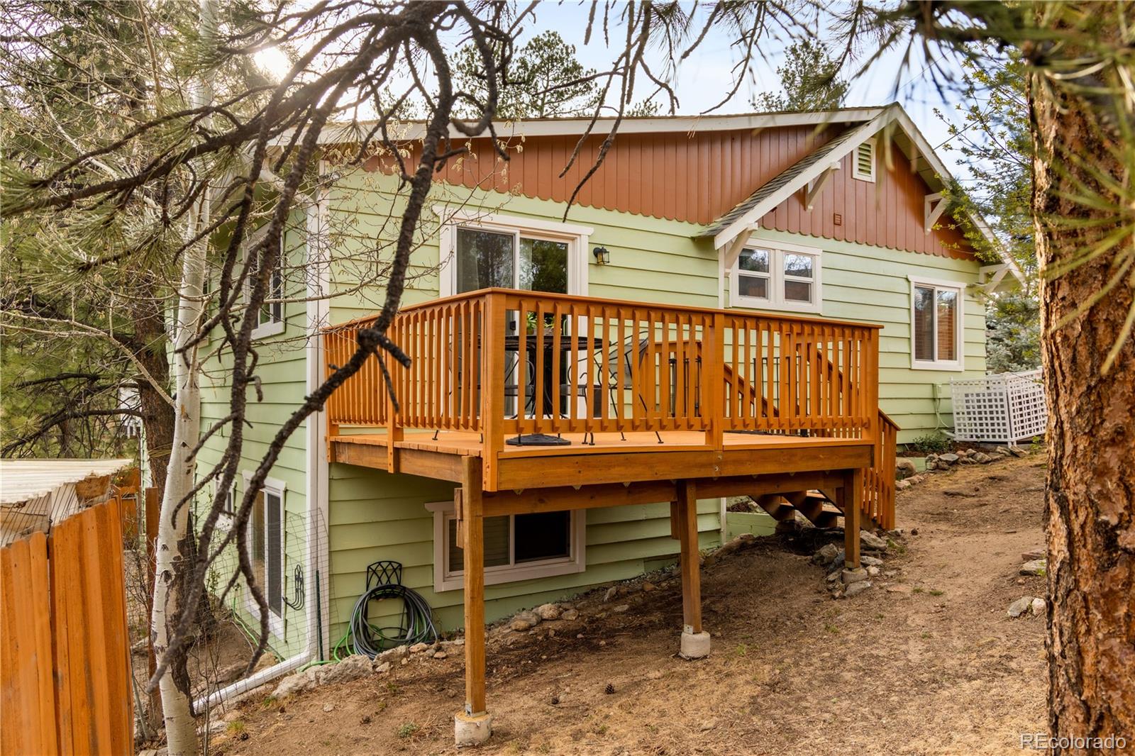 4805 Blue Spruce Road Evergreen, CO 80439 - Photo 19 of 43 a table and chair sitting in front of a house