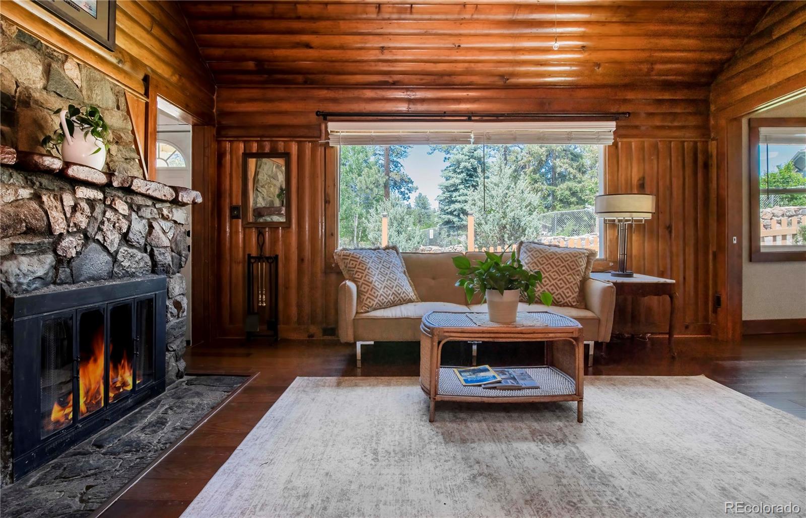 4805 Blue Spruce Road Evergreen, CO 80439 - Photo 20 of 43 a living room with furniture a window and a fireplace