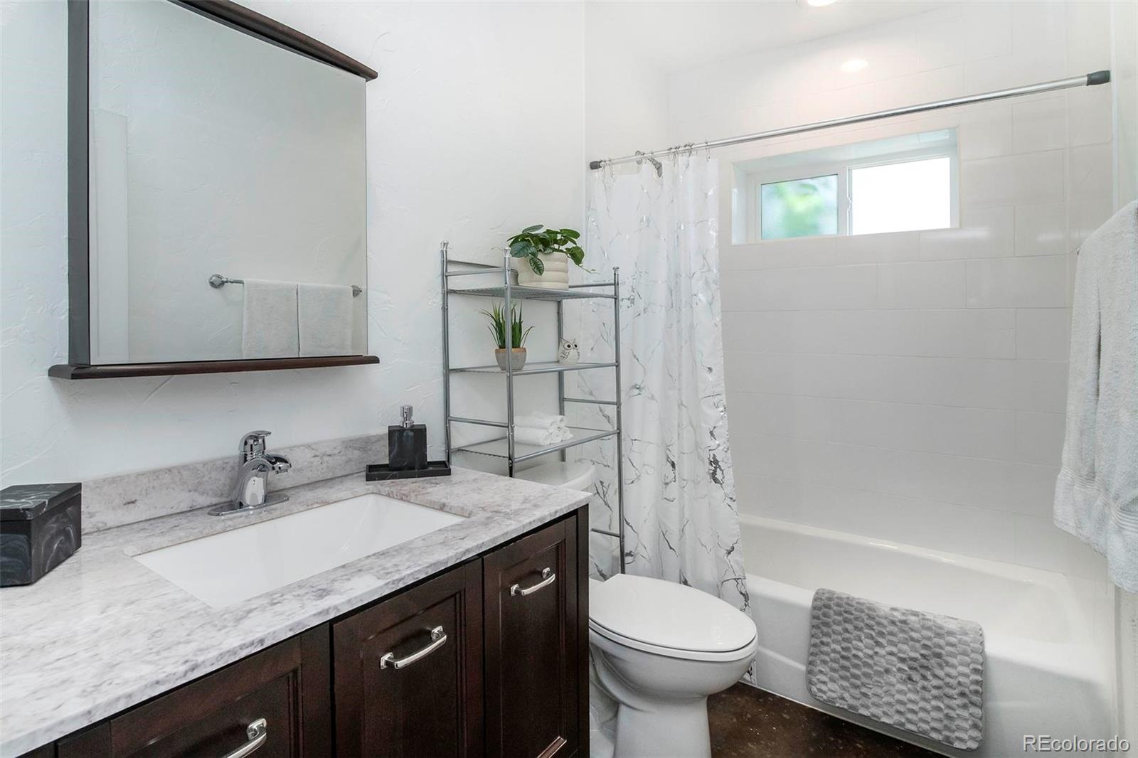 4805 Blue Spruce Road Evergreen, CO 80439 - Photo 30 of 43 a bathroom with a granite countertop sink toilet and shower