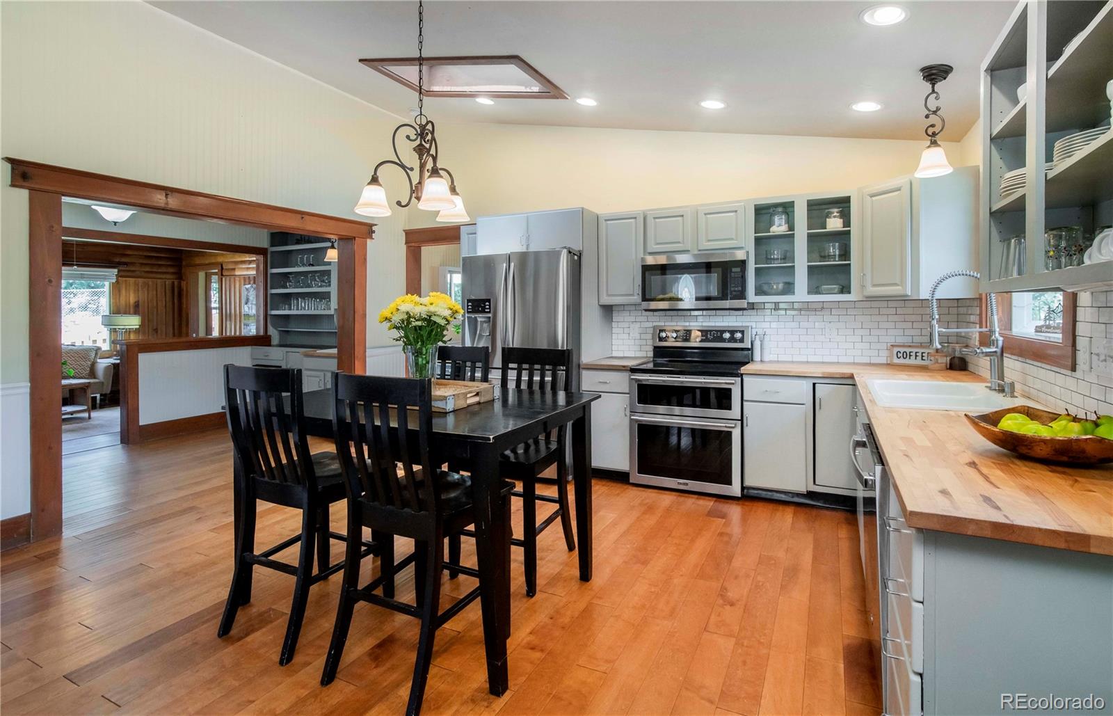 4805 Blue Spruce Road Evergreen, CO 80439 - Photo 8 of 43 a kitchen with stainless steel appliances granite countertop a stove top oven a sink a dining table and chairs