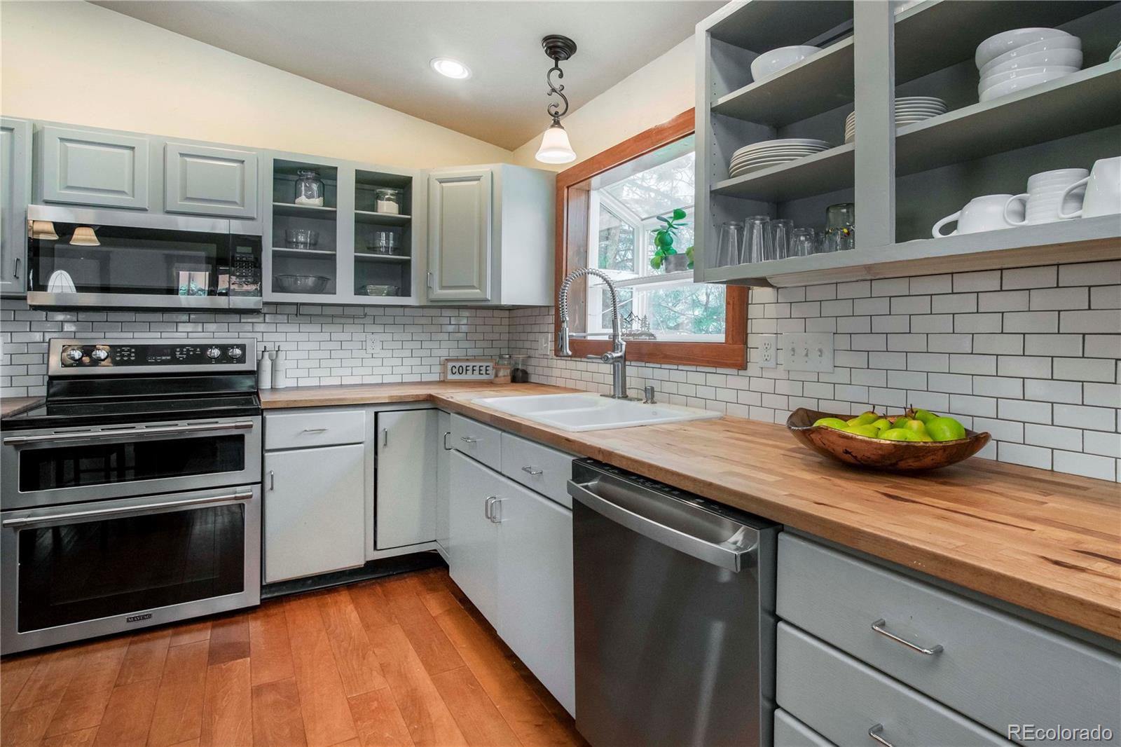 4805 Blue Spruce Road Evergreen, CO 80439 - Photo 9 of 43 a kitchen with stainless steel appliances a stove sink and microwave