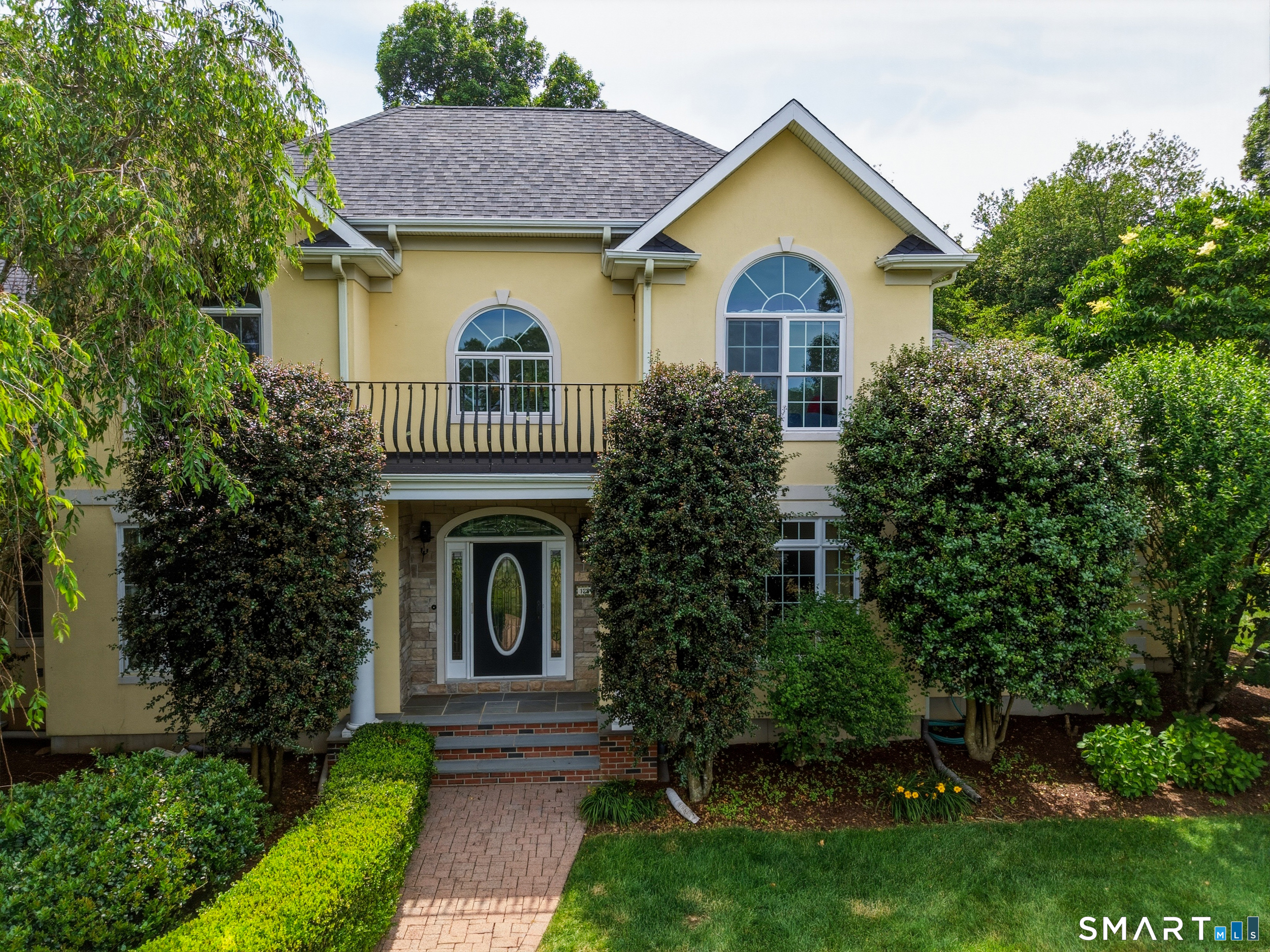 122 Lower Road Guilford, CT 06437 - Photo 3 of 40 Brick paver walkway leads to the front entrance of this distinctive stucco home, accented by stone detailing on the covered front porch. Above the entry, a charming balcony adds architectural character and timeless curb appeal.