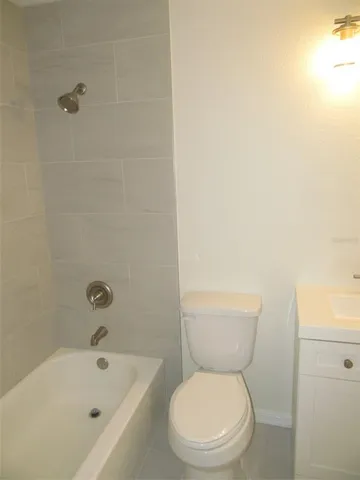 a white toilet sitting next to a bath tub