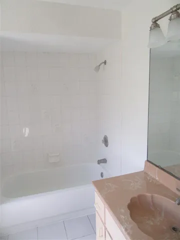 a bathroom with a granite countertop bathtub and shower