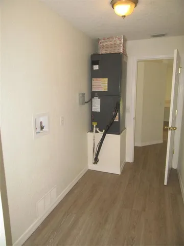 a view of a hallway with wooden floor and closet