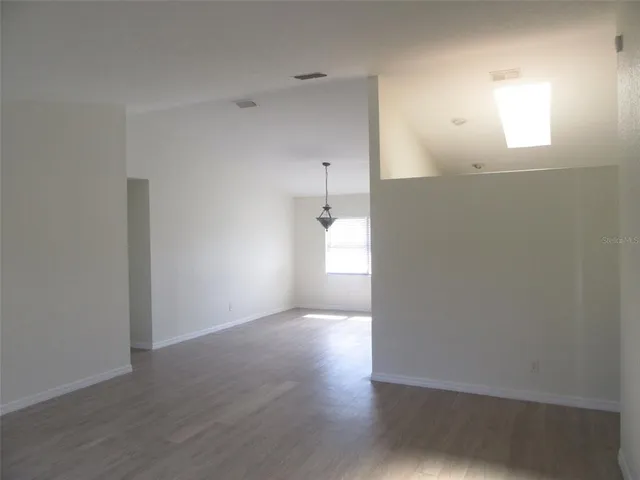 a view of a room with wooden floor and a window
