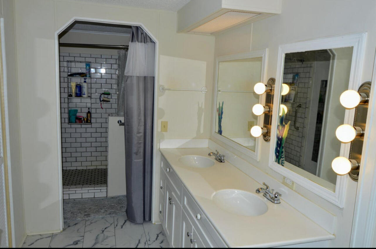 6554 Highway 441 Okeechobee, FL 34974 - Photo 13 of 22 a bathroom with a tub sink and mirror