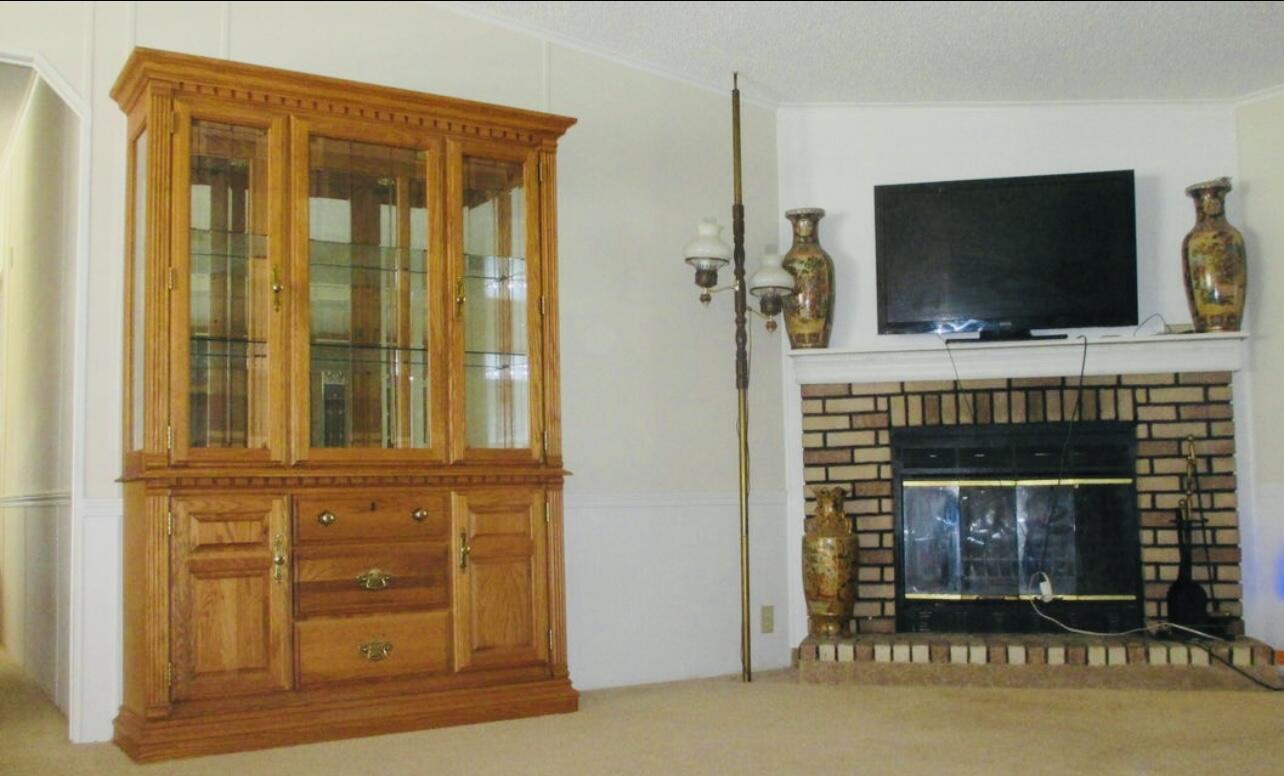 6554 Highway 441 Okeechobee, FL 34974 - Photo 9 of 22 a living room with a fireplace and a flat screen tv