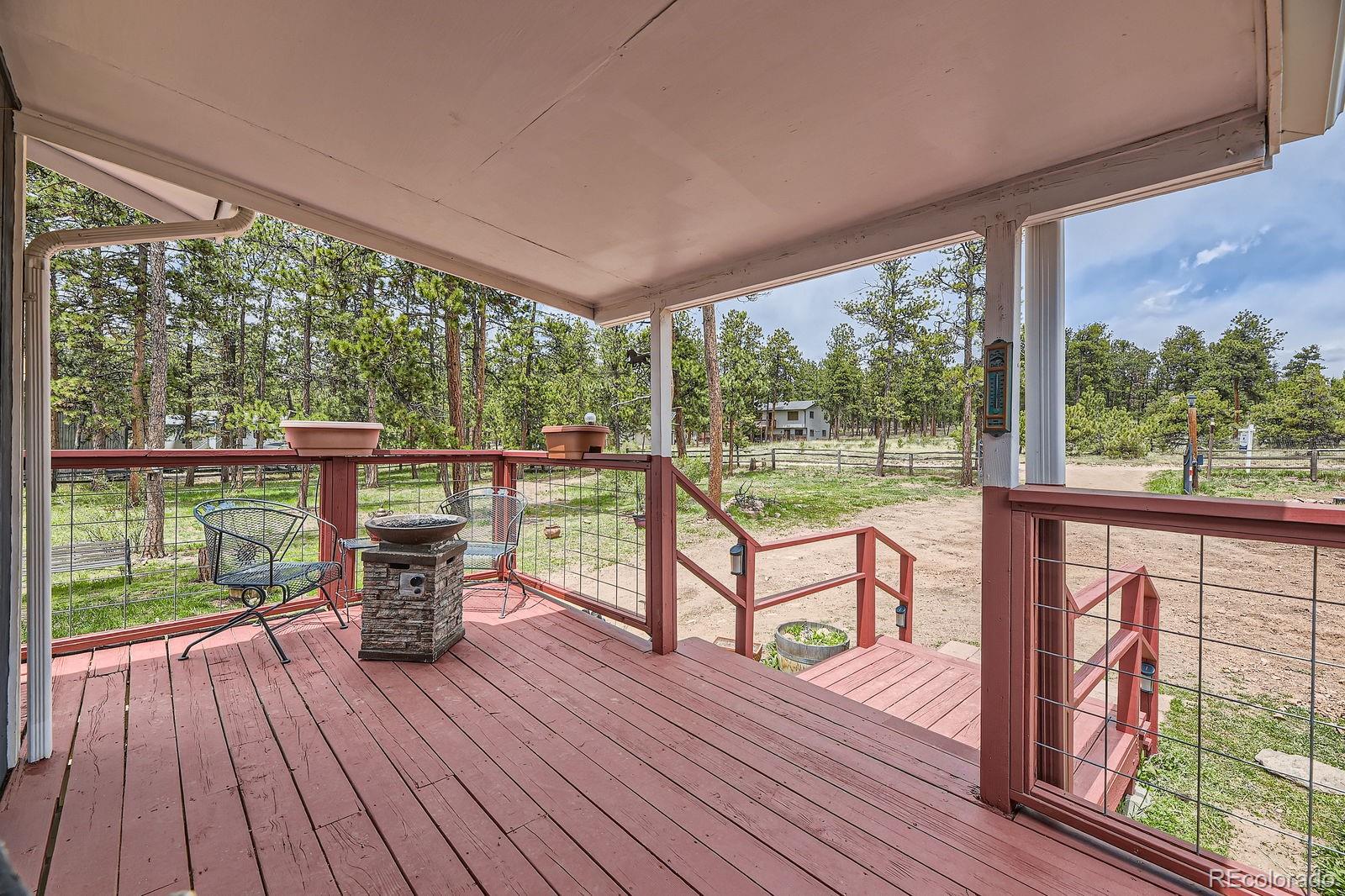 34886 Mohawk Trail Pine, CO 80470 - Photo 17 of 34 a view of a two chairs in the deck next to a yard