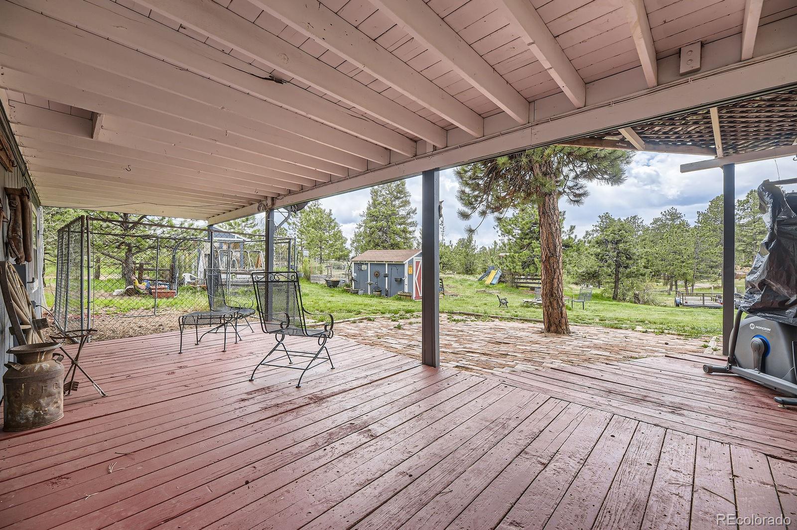 34886 Mohawk Trail Pine, CO 80470 - Photo 18 of 34 a view of a patio with table and chairs floor to ceiling window with wooden floor