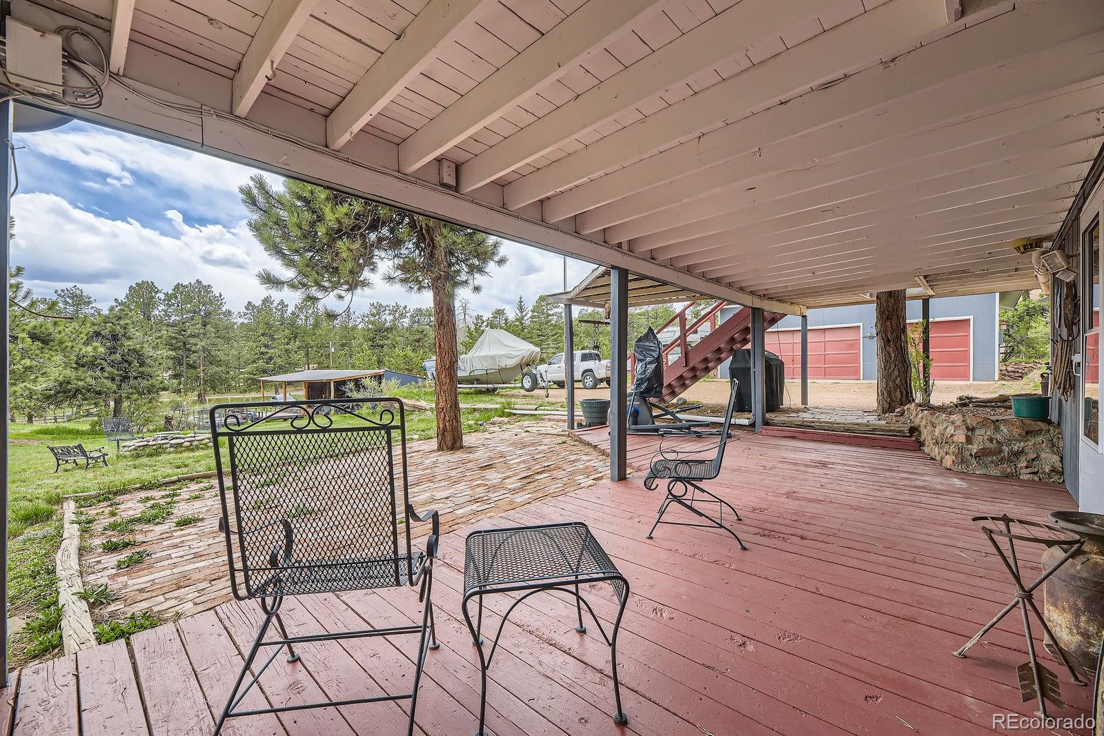 34886 Mohawk Trail Pine, CO 80470 - Photo 19 of 34 a view of a chairs and table in the patio next to a yard
