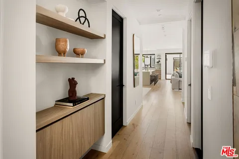 a living room with stainless steel appliances kitchen island granite countertop a couch a dining table and chairs with wooden floor