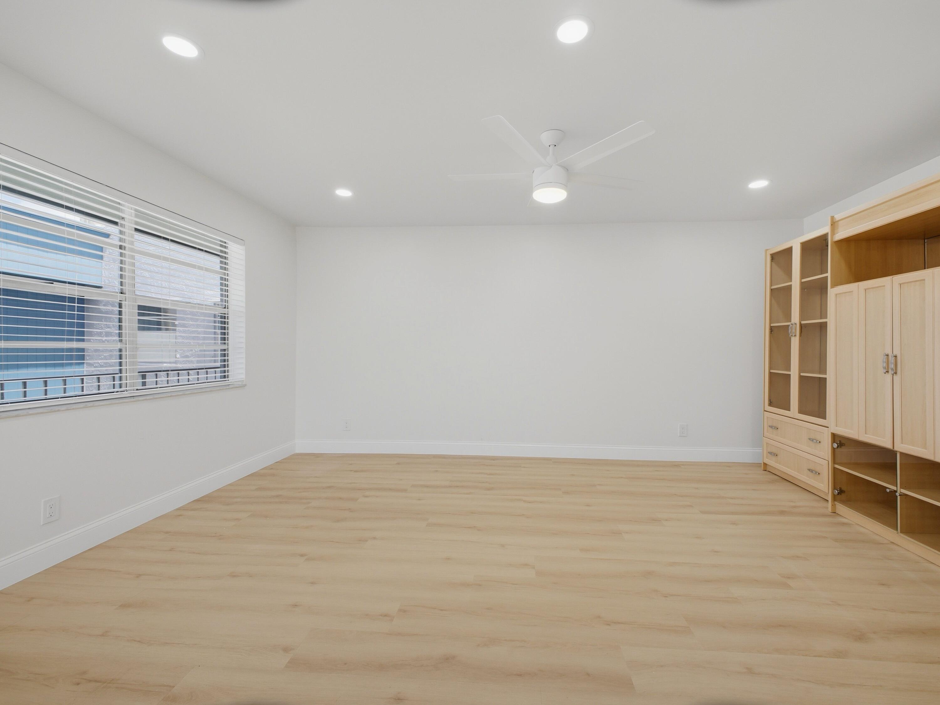 699 Flanders O Delray Beach, FL 33484 - Photo 12 of 39 a view of an empty room with wooden floor and a window