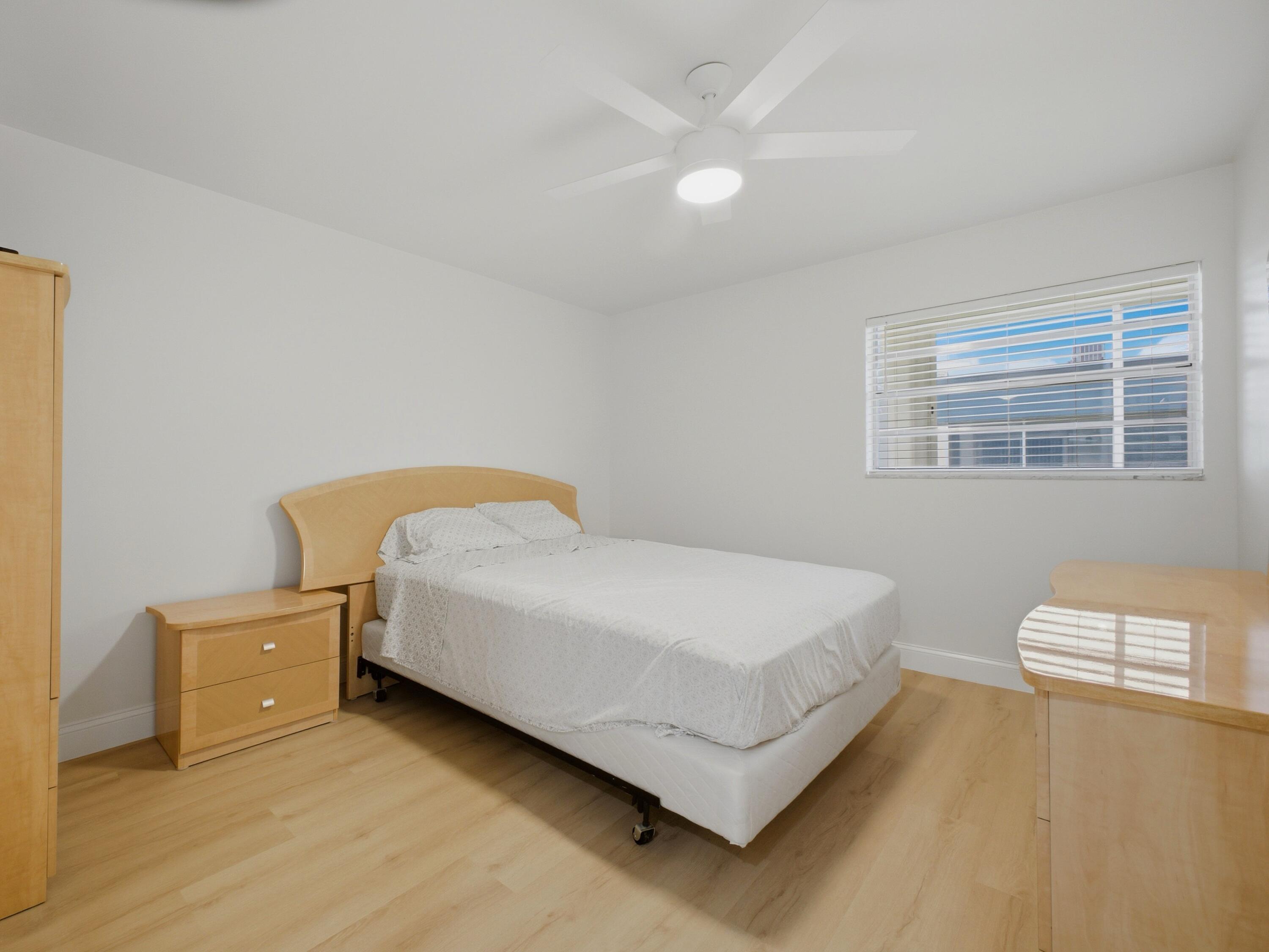 699 Flanders O Delray Beach, FL 33484 - Photo 16 of 39 a bed sitting in a bedroom next to a window