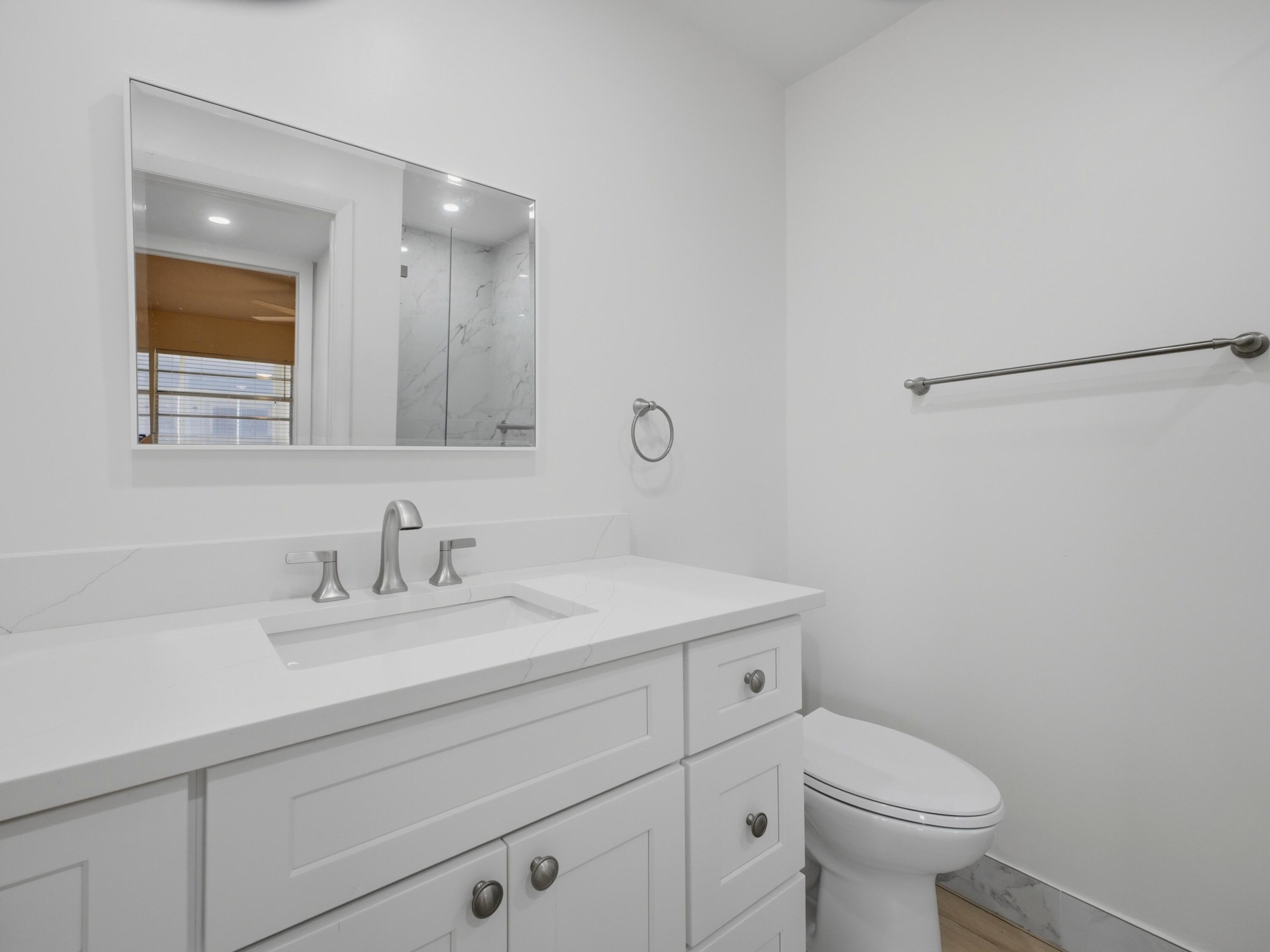 699 Flanders O Delray Beach, FL 33484 - Photo 20 of 39 a bathroom with a sink a toilet and a mirror