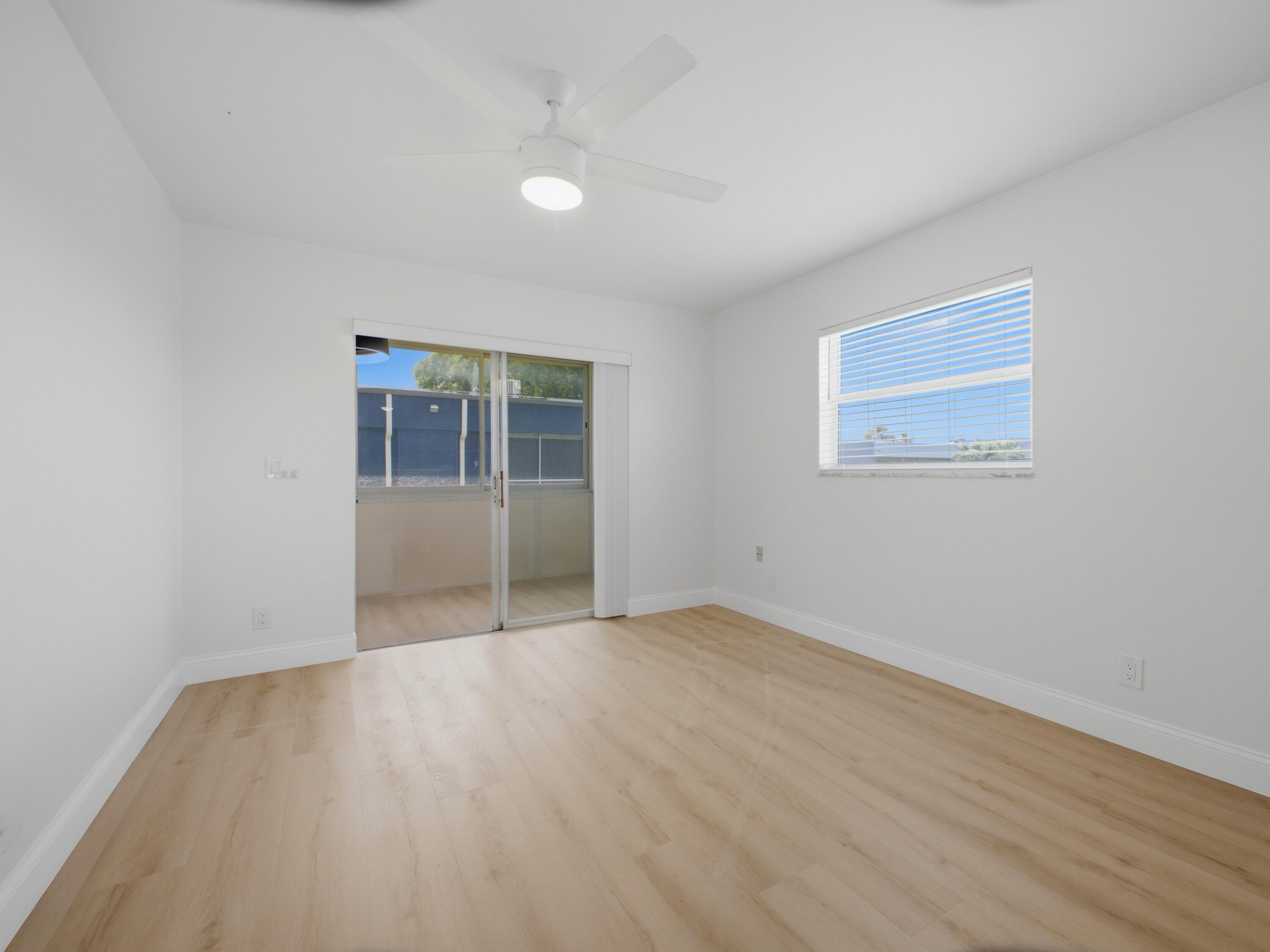 699 Flanders O Delray Beach, FL 33484 - Photo 23 of 39 an empty room with wooden floor and windows