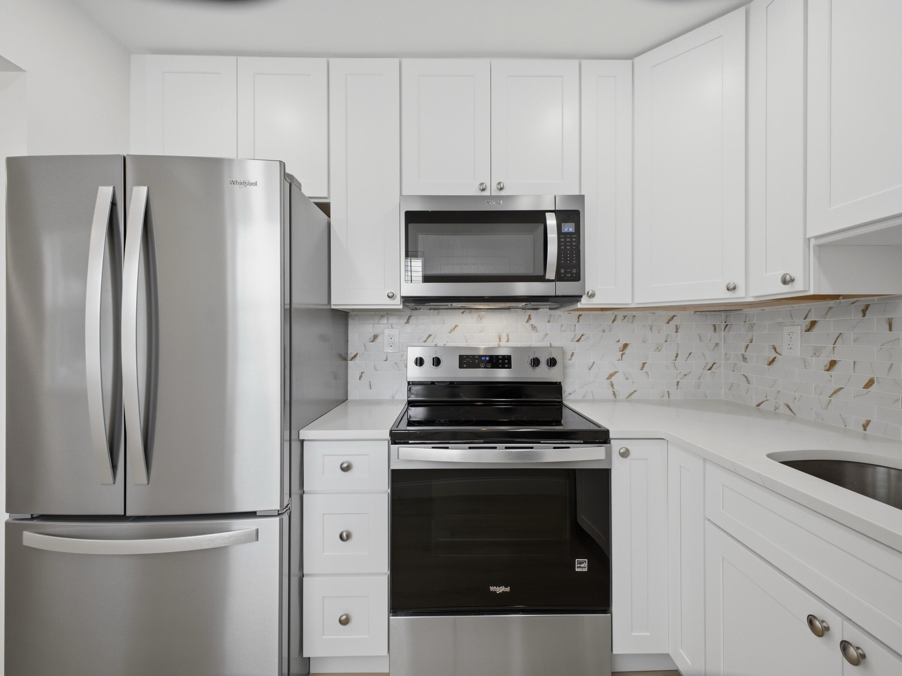 699 Flanders O Delray Beach, FL 33484 - Photo 3 of 39 a kitchen with cabinets stainless steel appliances and a sink