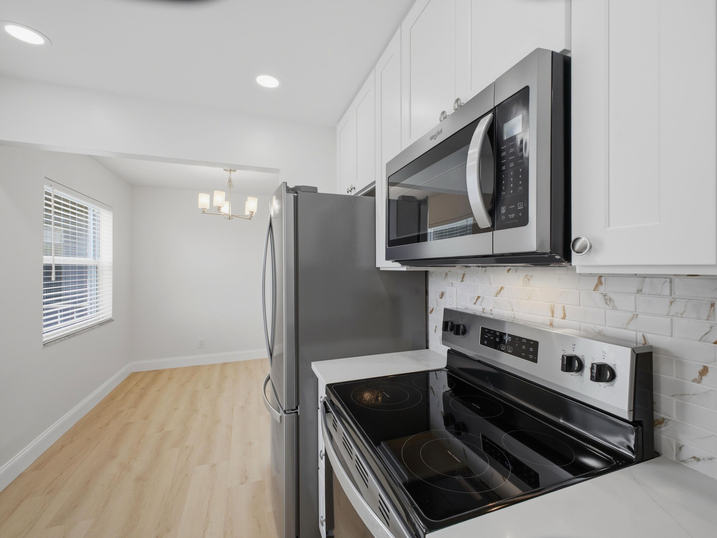 699 Flanders O Delray Beach, FL 33484 - Photo 4 of 39 a kitchen with granite countertop a stove and a microwave