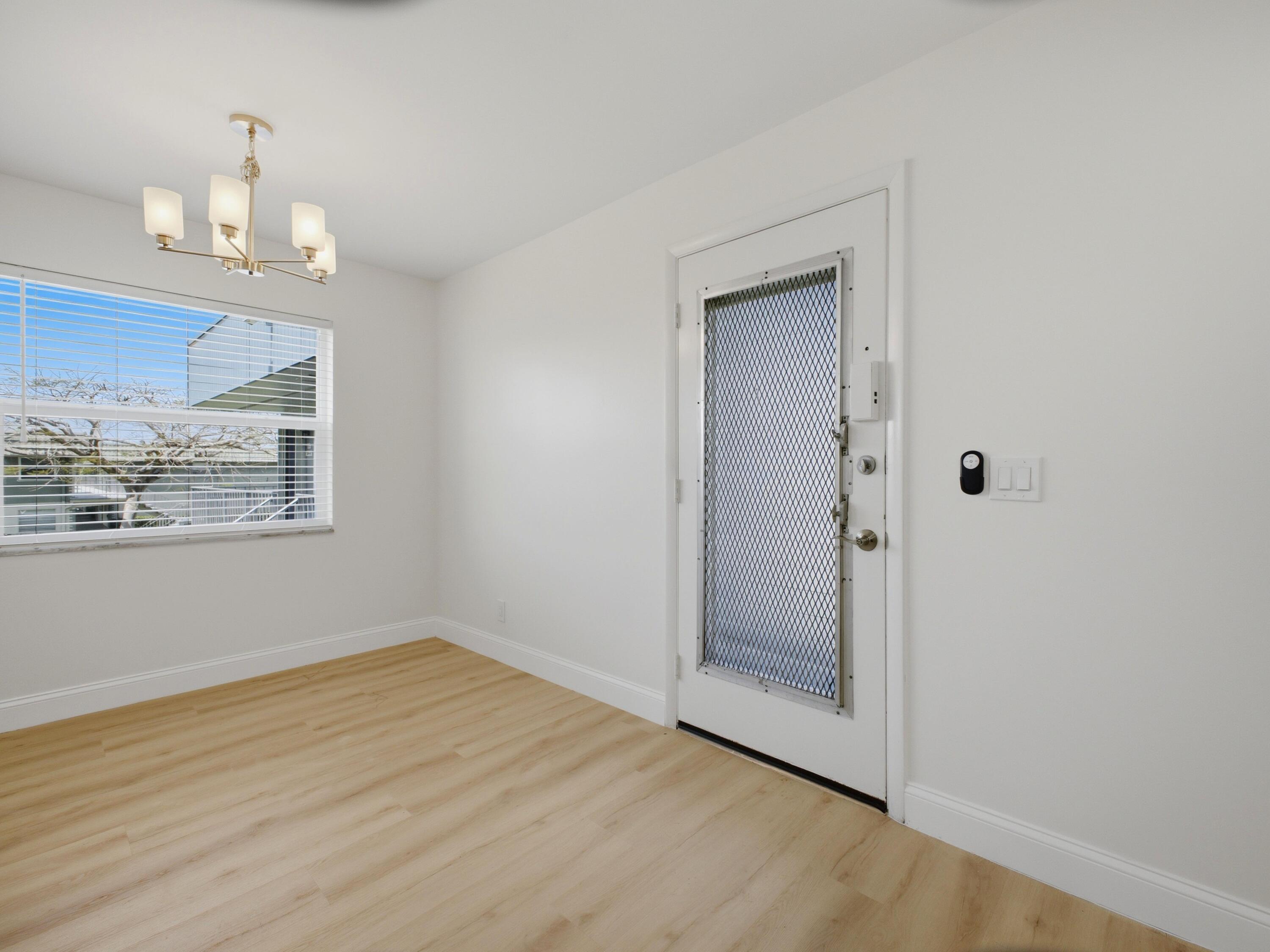699 Flanders O Delray Beach, FL 33484 - Photo 9 of 39 a view of an empty room with wooden floor and a window