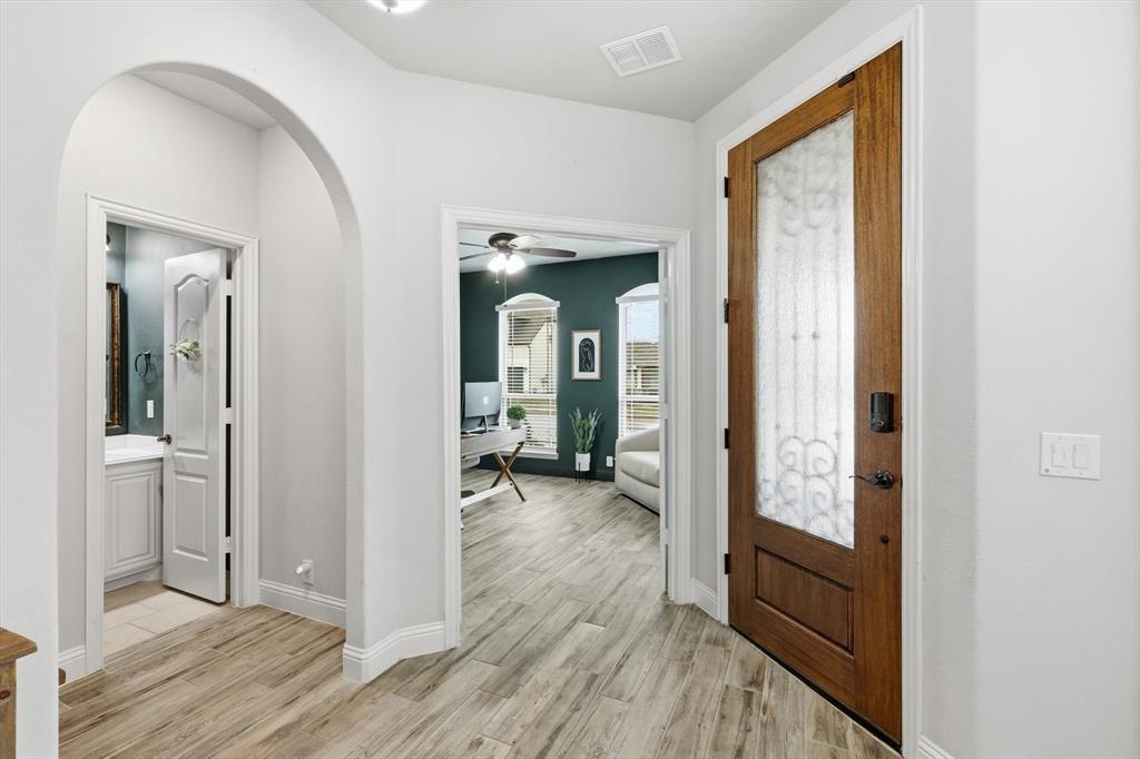 924 Timber Ridge Drive Justin, TX 76247 - Photo 2 of 32 Entryway featuring wood-finish flooring, a solid wood entry door with decorative glass, and a smart lock