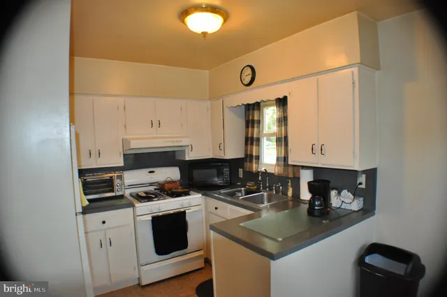 a kitchen with a sink a stove and cabinets