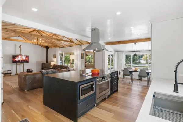 a kitchen with stainless steel appliances granite countertop a sink and a large window