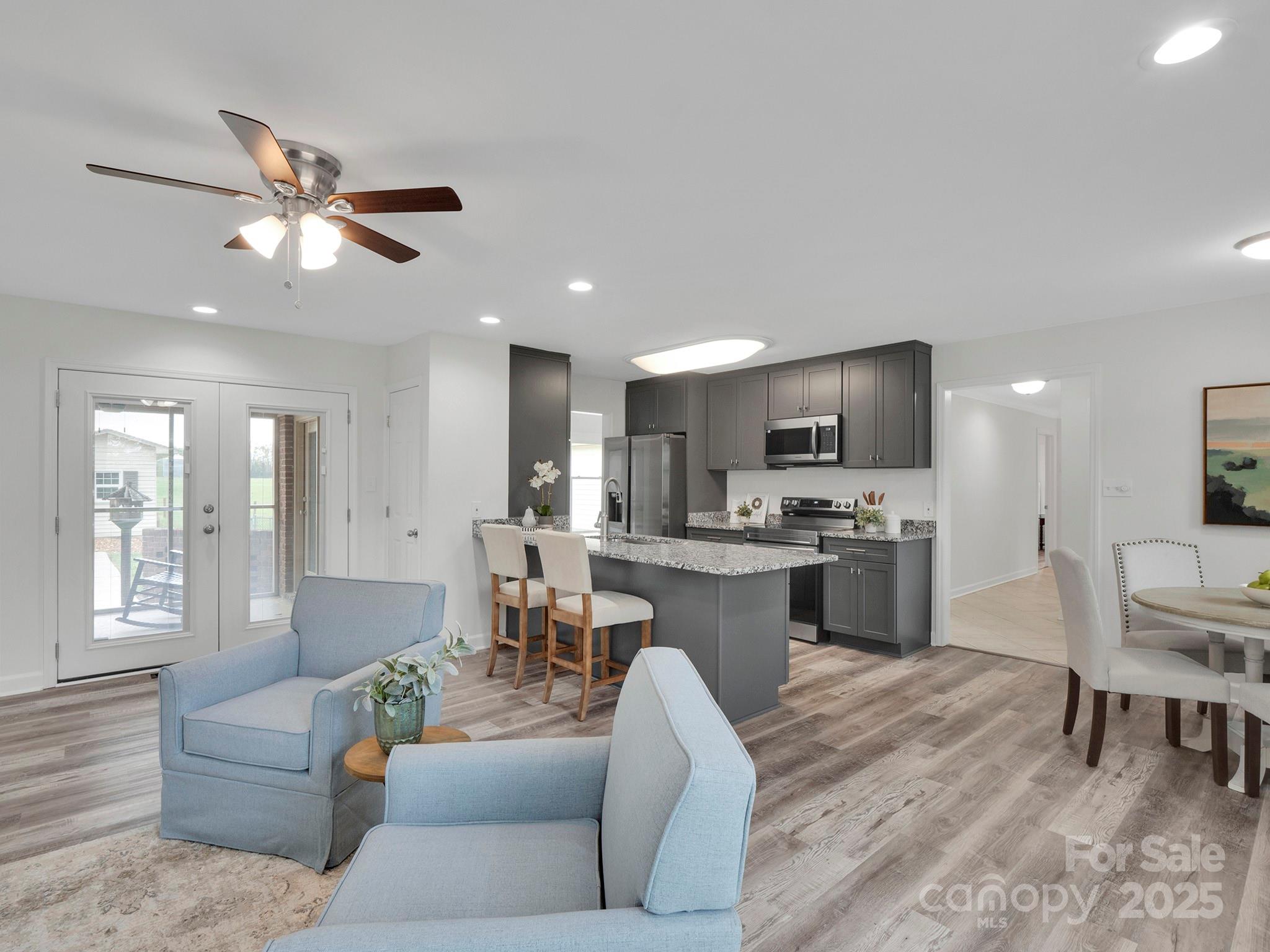 3452 Flat Creek Road Lancaster, SC 29720 - Photo 6 of 34 a living room with couches a kitchen with kitchen island with furniture and a flat screen tv