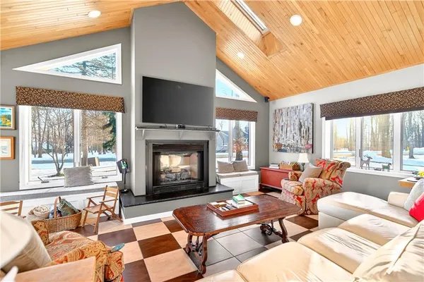 a living room with furniture a large window and a fireplace