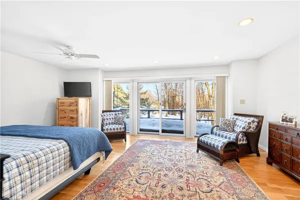 a bedroom with a bed a couch and large window with the outer view