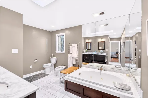 a bathroom with a tub sink and mirror