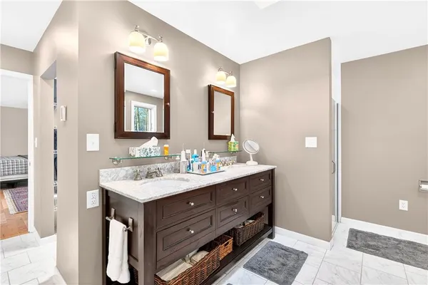 a bathroom with a sink mirror and a shower