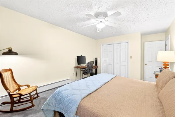 a bedroom with a bed a chair and the potted plant